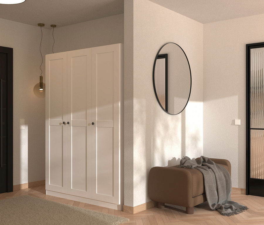 Ein Flur mit einem weißen dreitürigen Schrank, einem runden Spiegel und einer braunen Bank mit einer grauen Decke.