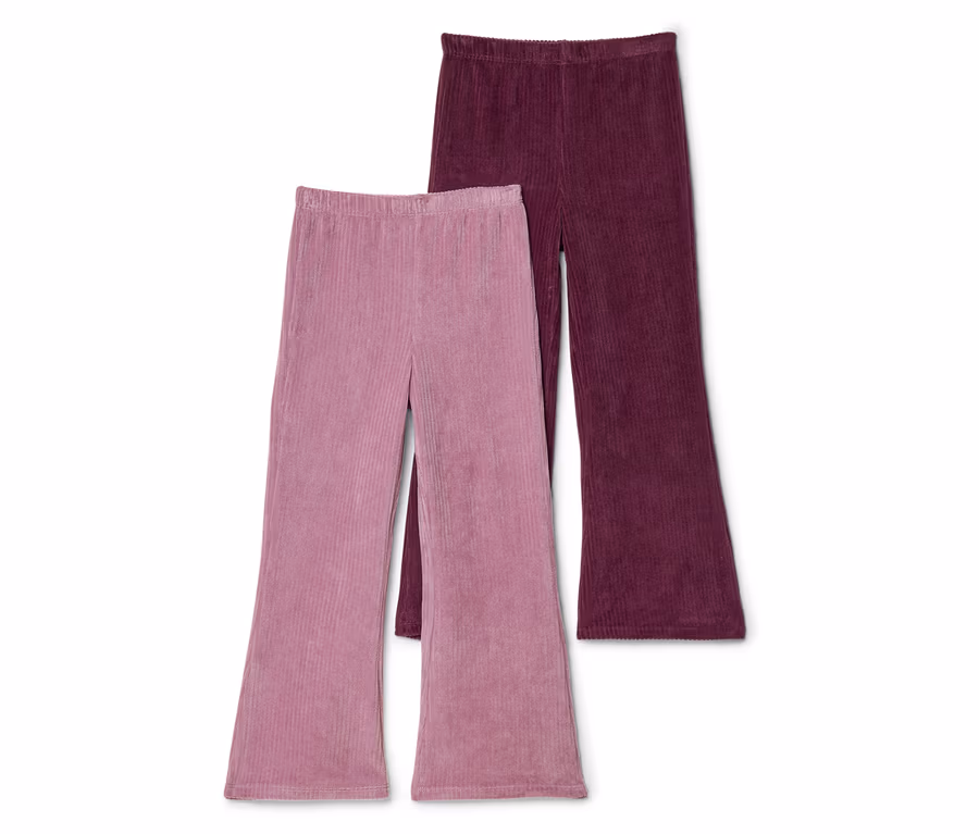 Zwei ausgestellte Cordhosen, eine rosa und eine weinrot, liegen nebeneinander auf einem weißen Hintergrund.