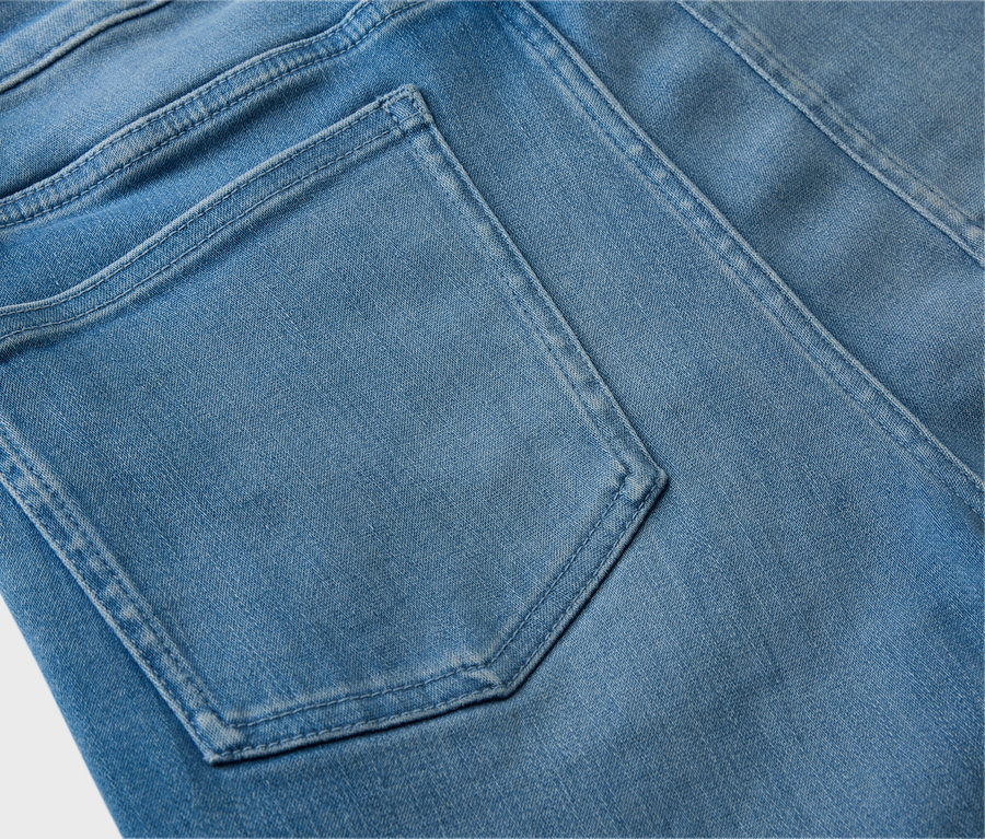 Nahaufnahme der Rückseite einer hellblauen Jeans mit einer Gesäßtasche.