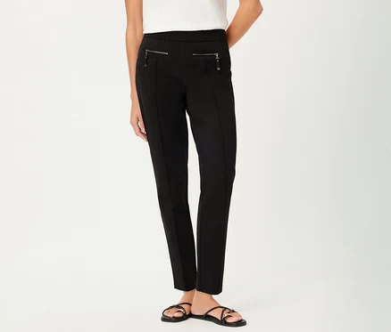 Frau trägt eine Olsen Hose, slim, in Schwarz mit Reißverschlusstaschen und schwarze Sandalen vor einem weißen Hintergrund.