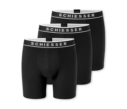 Drei schwarze Boxershorts, leicht versetzt hintereinander angeordnet, mit weißem Bund und „SCHIESSER“-Logo.