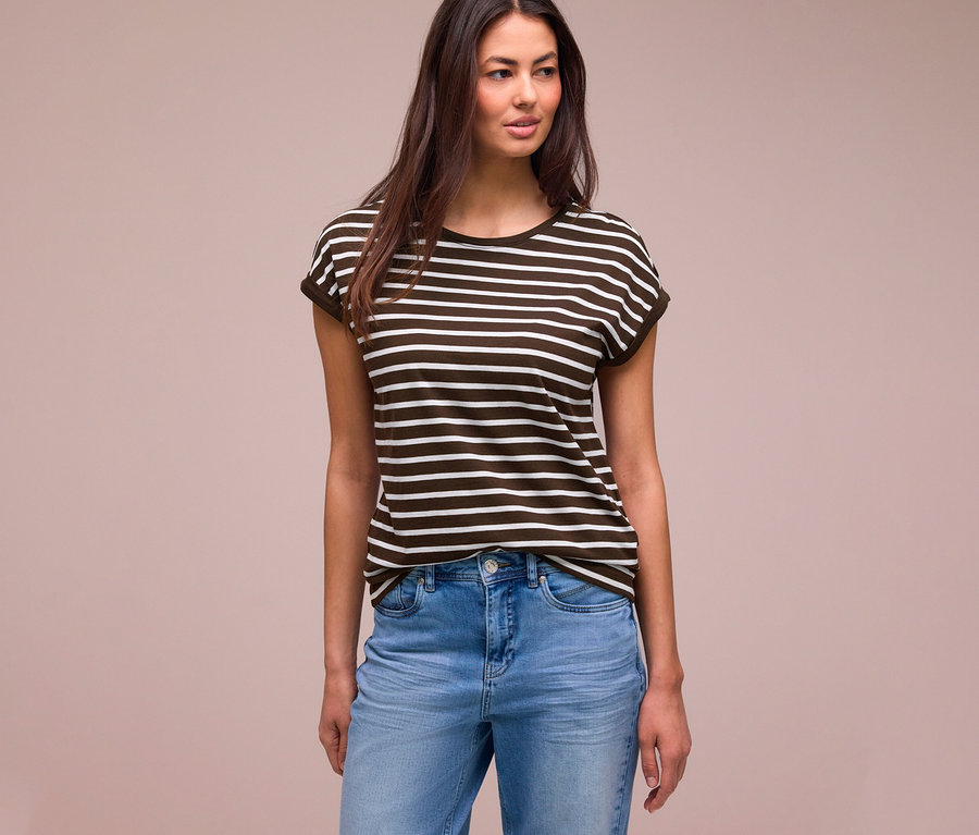 Frau mit langen dunklen Haaren trägt ein dunkelbraun-weiß gestreiftes Street One T-Shirt und hellblaue Jeans, blickt nach rechts.