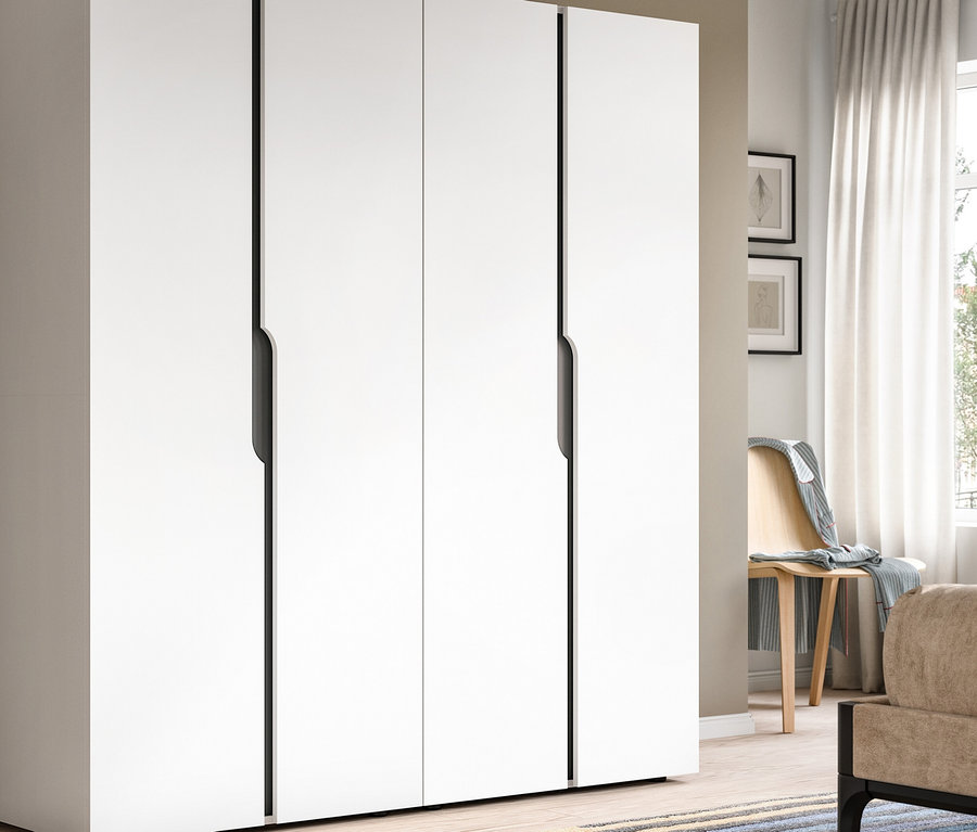 Großer weißer viertüriger Kleiderschrank mit dunklen Griffmulden in einem modernen Raum. Rechts sind ein Fenster mit weißen Vorhängen, ein Holzstuhl, ein Bett und ein Nachttisch mit Lampe zu sehen.