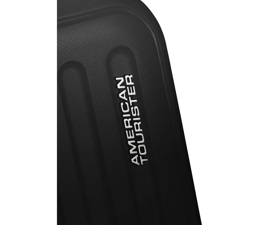 Nahaufnahme eines schwarzen American Tourister »Rejoy Spinner« Koffers, der das weiß geprägte „AMERICAN TOURISTER“-Logo auf seiner strukturierten Oberfläche zeigt.