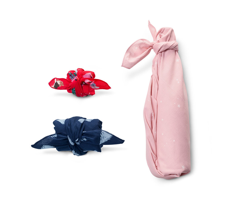 Drei Geschenke, verpackt in Stoff-Geschenkpapier in verschiedenen Farben.
