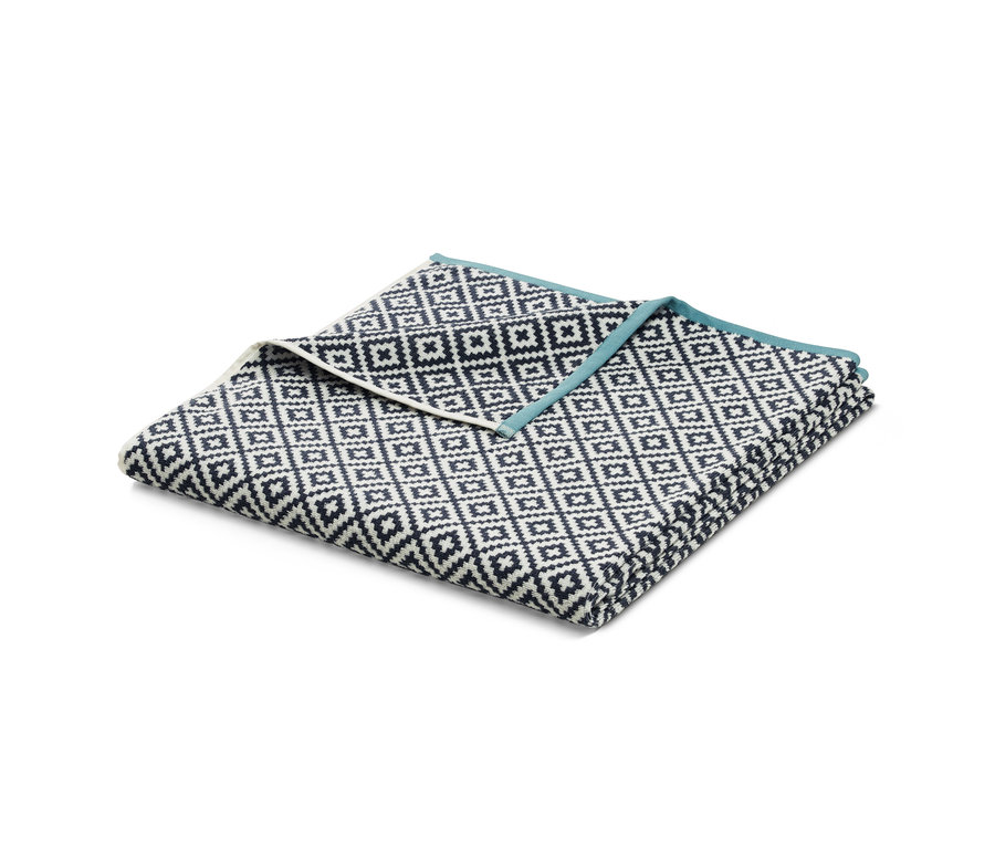 Gefaltetes XL-Frottier-Badetuch, ca. 200 x 100 cm, mit schwarz-weißem geometrischen Muster und hellblauer Bordüre.