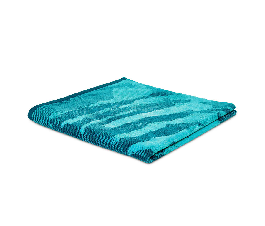 Nahaufnahme eines gefalteten XL-Velours-Badetuchs mit blauem Tiger-Muster.