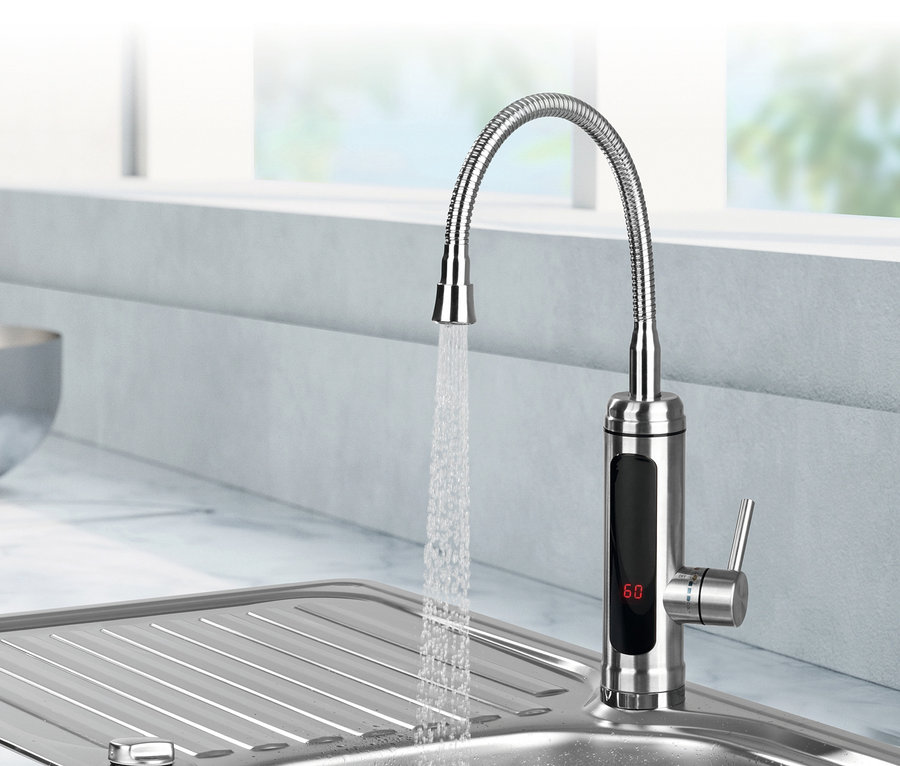 Wasser fließt aus der elektrischen Edelstahlarmatur MAXXMEE mit integriertem Durchlauferhitzer in ein Edelstahlspülbecken.