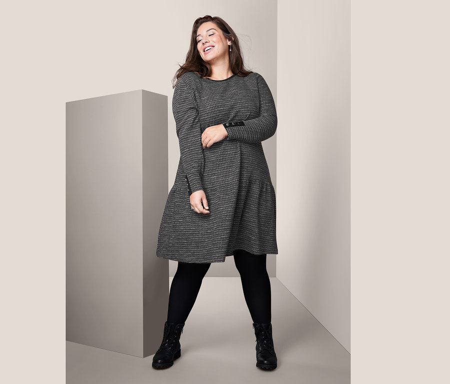 Frau posiert in einem strukturierten Kleid.