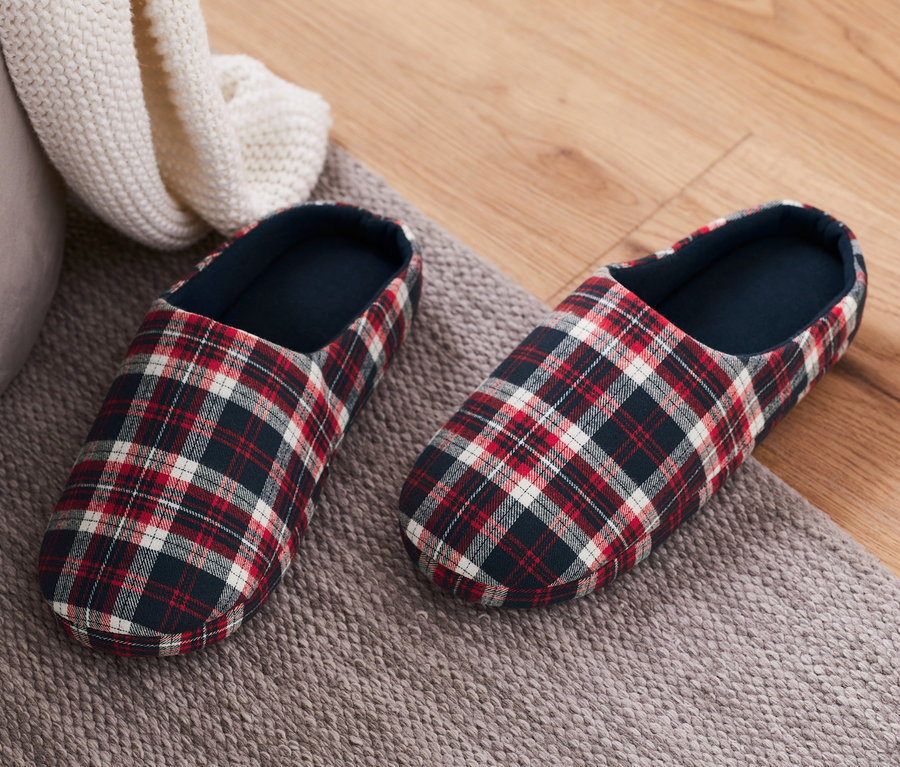 Zwei karierte Hausschuhe auf einem grauen Teppich.