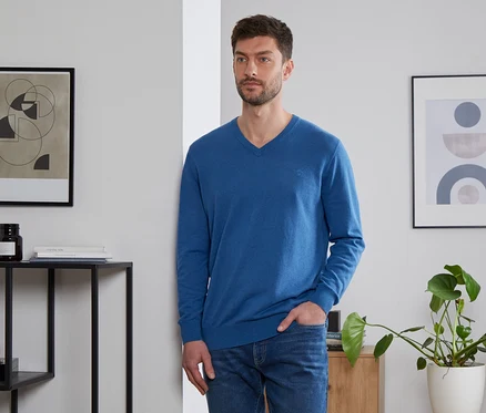 Mann mit Hand in Tasche trägt einen royalblauen Leinen-Pullover.