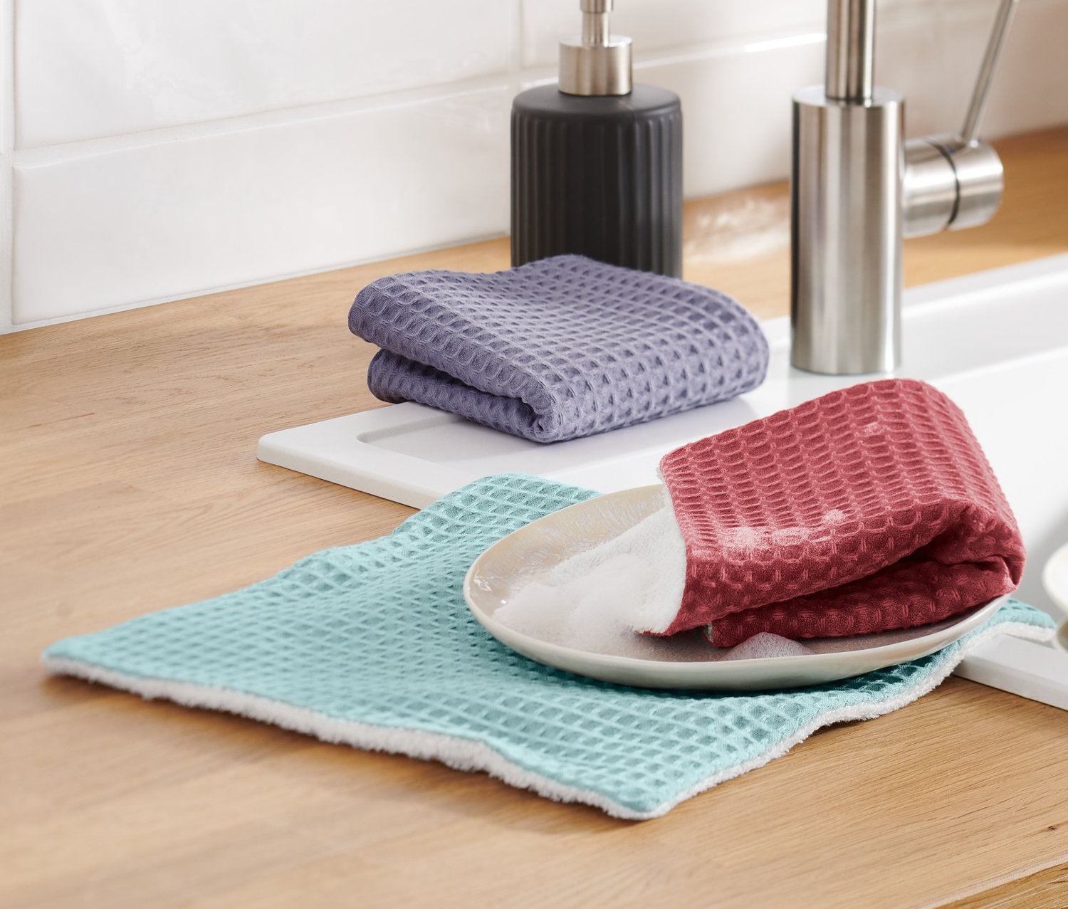 Drei Spültücher liegen auf der Küchentheke.