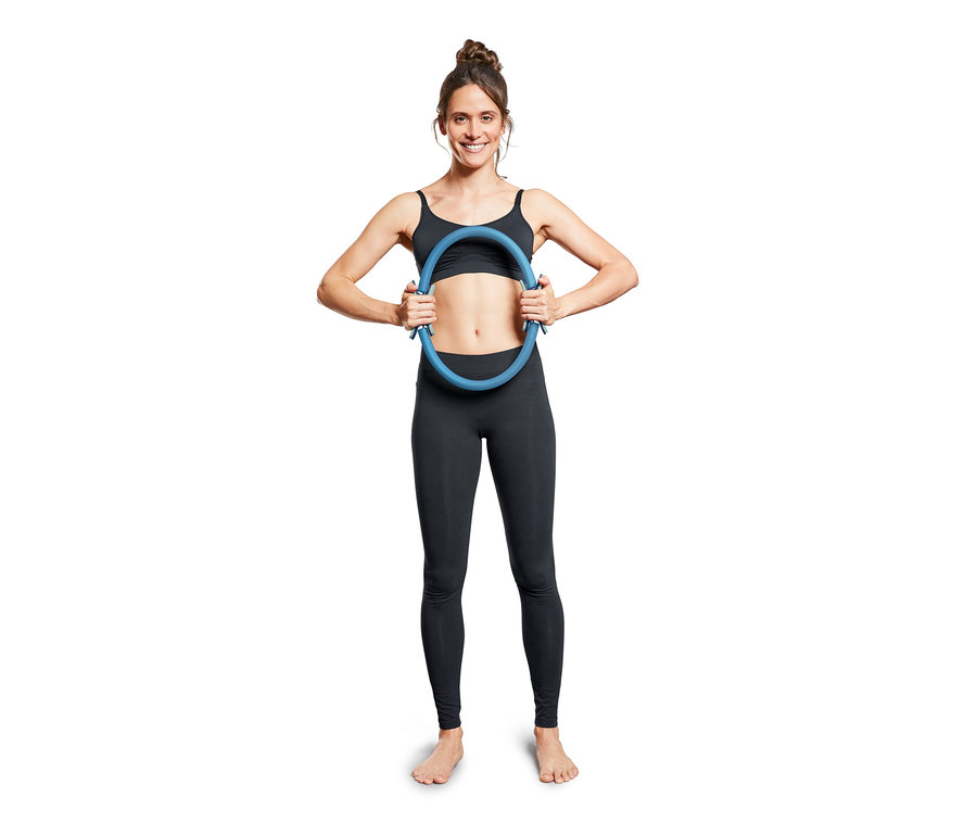 Frau hält blauen Pilatesring.