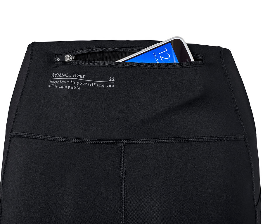 Detail einer schwarzen Performance-Lauftight für Damen mit einem Telefon in der Tasche.