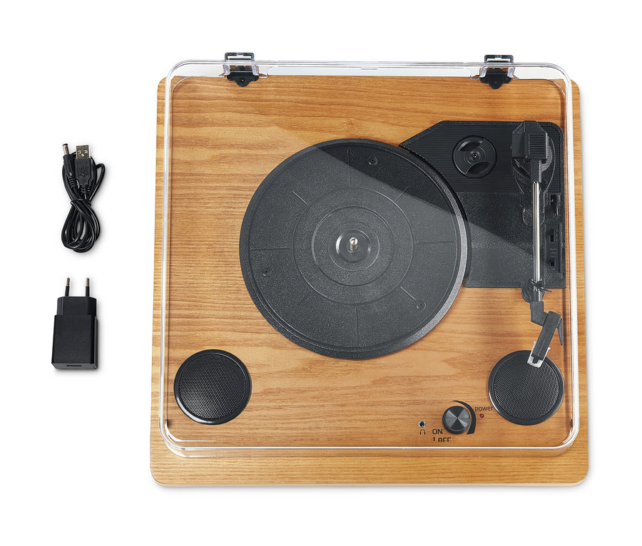 Ein Dual DTR 61 Schallplattenspieler mit eingebauten Lautsprechern, Holzoberfläche, schwarzem Plattenteller und Bedienelementen, zusammen mit Netzteil und USB-Kabel.
