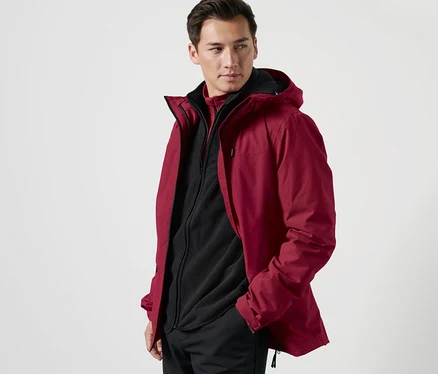 Mann posiert in Outdoorjacke mit Weste.