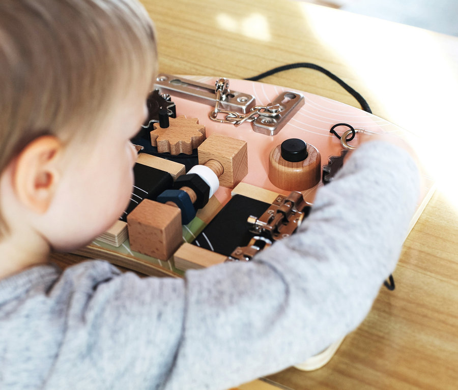 Kind spielt mit small foot Motorikbrett »Schlösser und Rotation«.