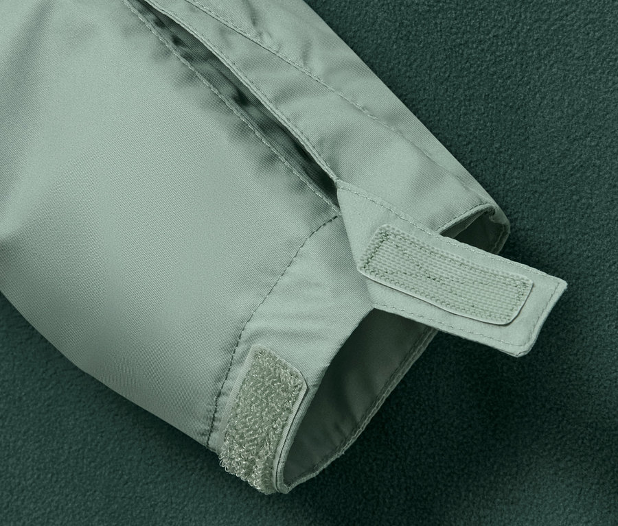 Detail des Ärmels einer Kinder-Allwetterjacke mit Klettverschluss.