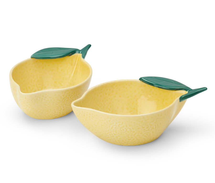 Zwei kleine gelbe Schalen in Zitronenform mit grünen Blättern.