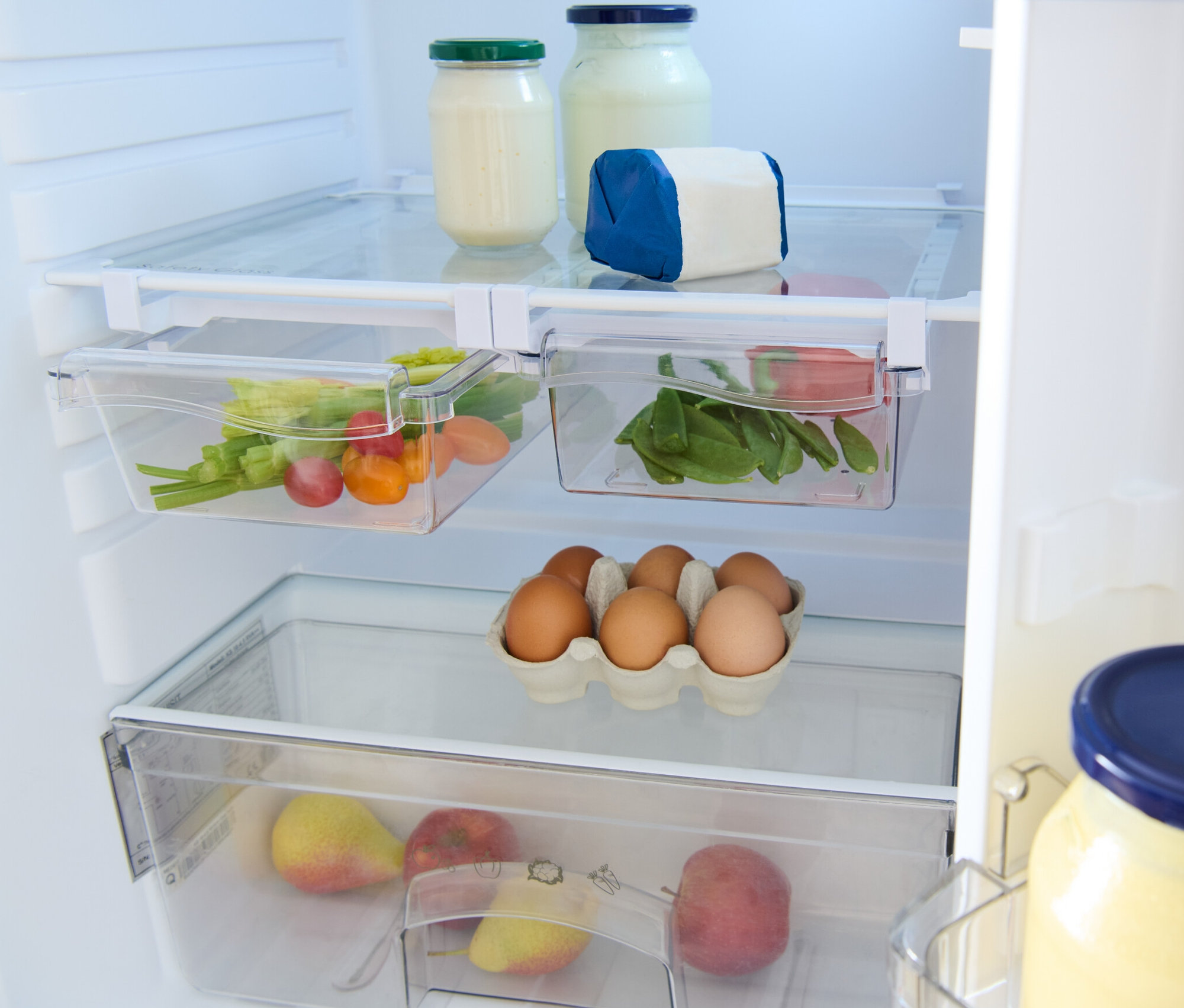 Im Kühlschrank befinden sich 2 ausziehbare Kühlschrankkörbe, Gläser, Eier und Obst.