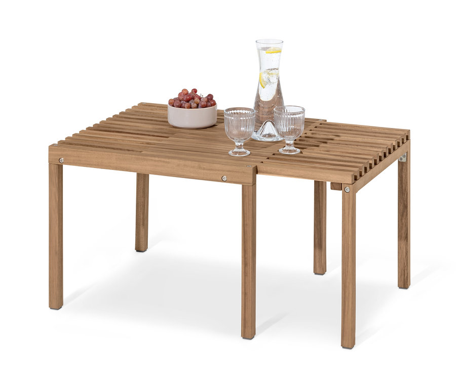Ausgezogener Holztisch mit zwei Gläsern, einer Wasserkaraffe und einer Schale Obst.