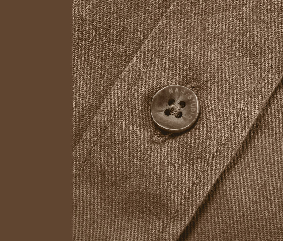 Detailaufnahme einer haselnussbraunen NAH/STUDIO Hemdbluse aus nachhaltiger Baumwolle, Knopf sichtbar.