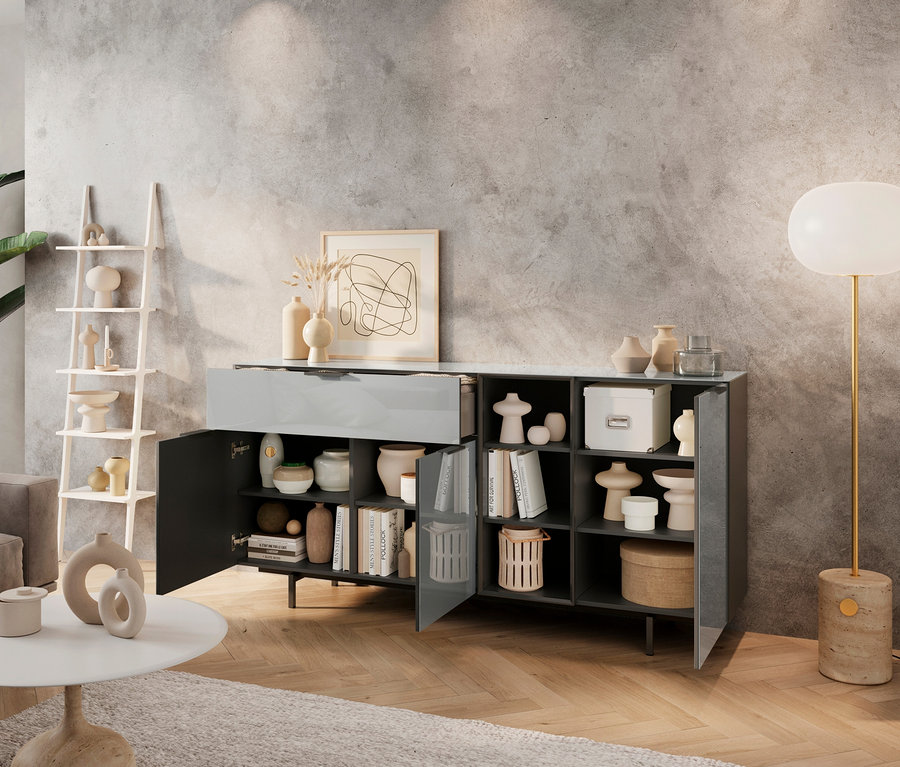 Wohnzimmer mit einem Sideboard aus Glas, Dekorationen und einer Lampe.