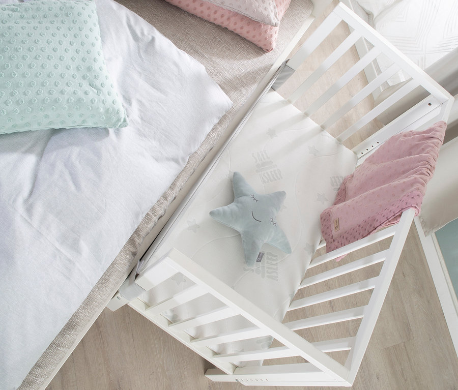 Detailansicht von oben eines weißen roba 2-in-1-Beistellbettes »safe asleep®«, das mit einem Bett verbunden ist.