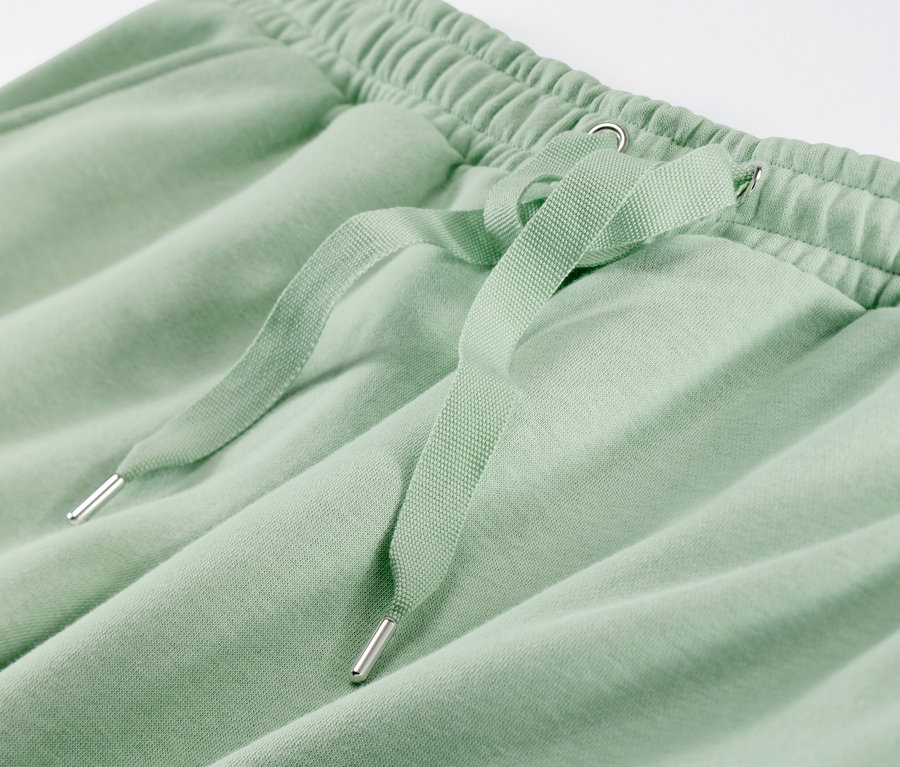 Detailaufnahme eines grünen Hausanzugs mit Kordelzug.