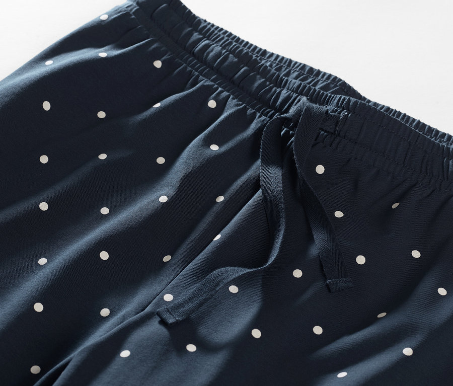 Detailaufnahme einer marineblauen Pyjamahose mit weißen Punkten.