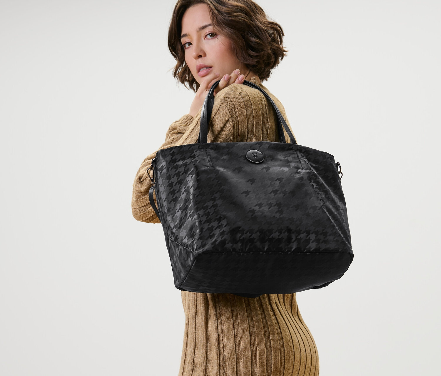 Frau posiert mit schwarzem Shopper.