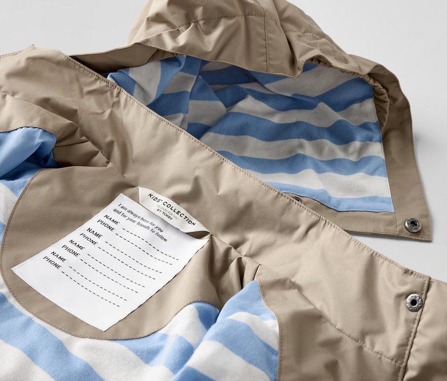 Detailansicht einer braunen Kinder-Regenjacke mit blau-weiss gestreiftem Innenfutter.