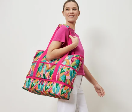 Frau trägt eine Strandtasche mit Alloverprint.