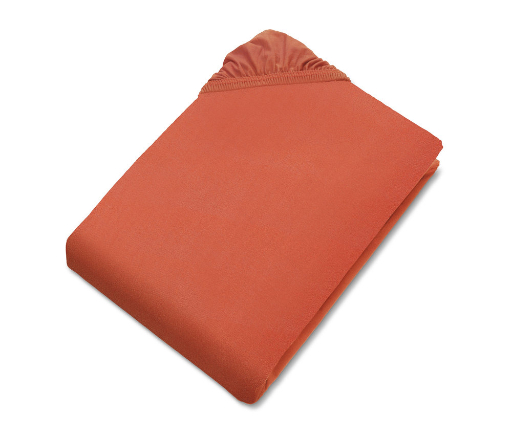 Nahaufnahme eines korallenroten Spannbettlakens der SCHÖNER WOHNEN-Kollektion.