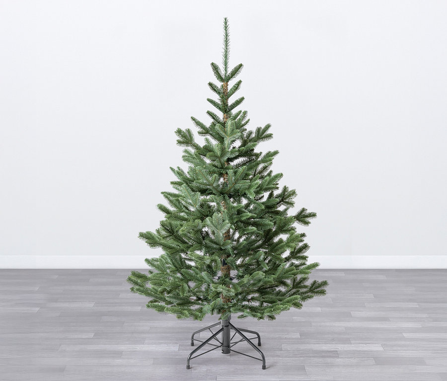 Ein künstlicher Weihnachtsbaum mit Ständer Evergreen »Nobilis S«, 150 cm steht auf einem grauen Holzboden vor einer weißen Wand.
