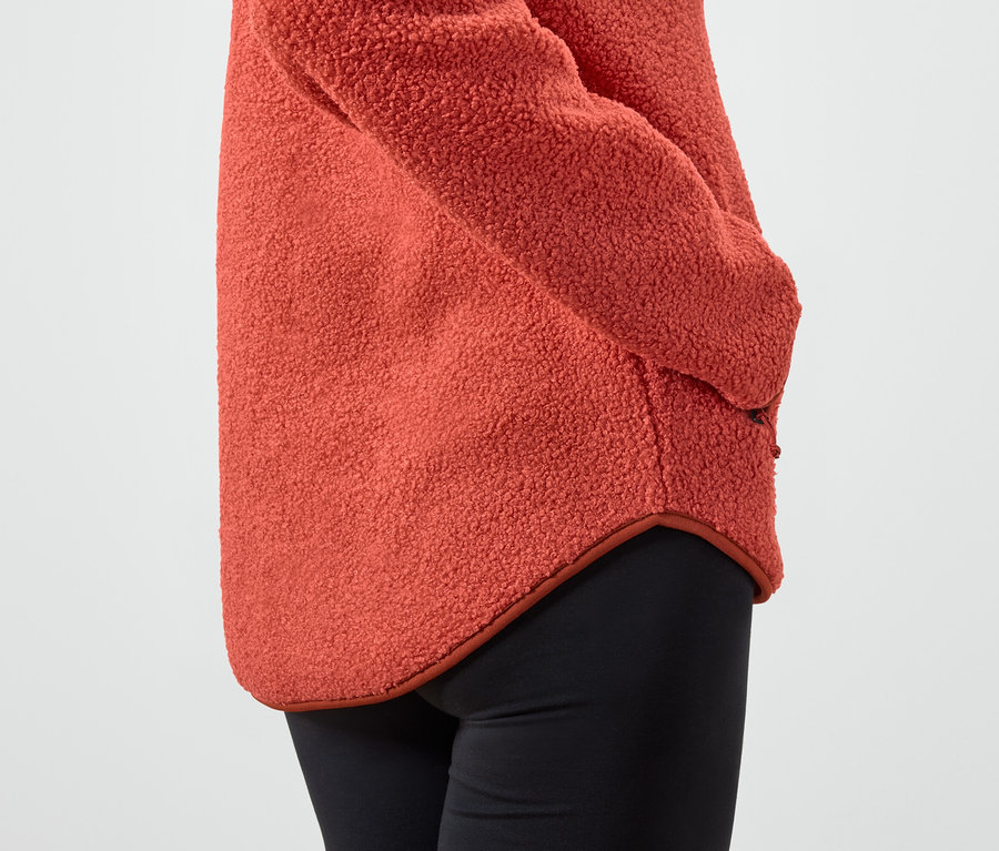 Detailaufnahme einer orangefarbenen Damen-Fleecejacke und schwarzen Leggings.