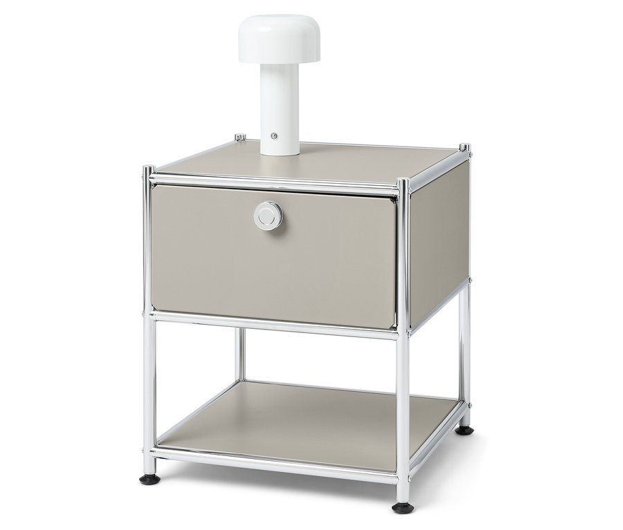 Nachttisch mit Schublade und einer weißen Lampe darauf.