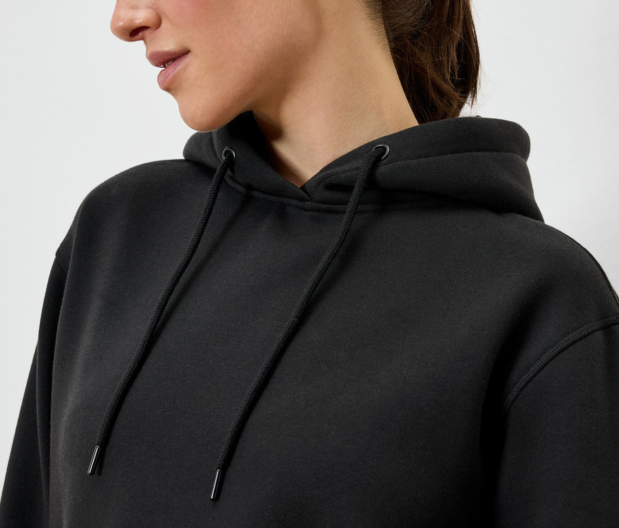 Frau trägt einen schwarzen Hoodie.