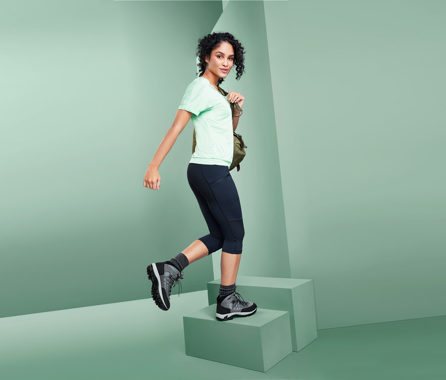 Frau steigt Stufen in 3/4-Trekking-Tights hoch.