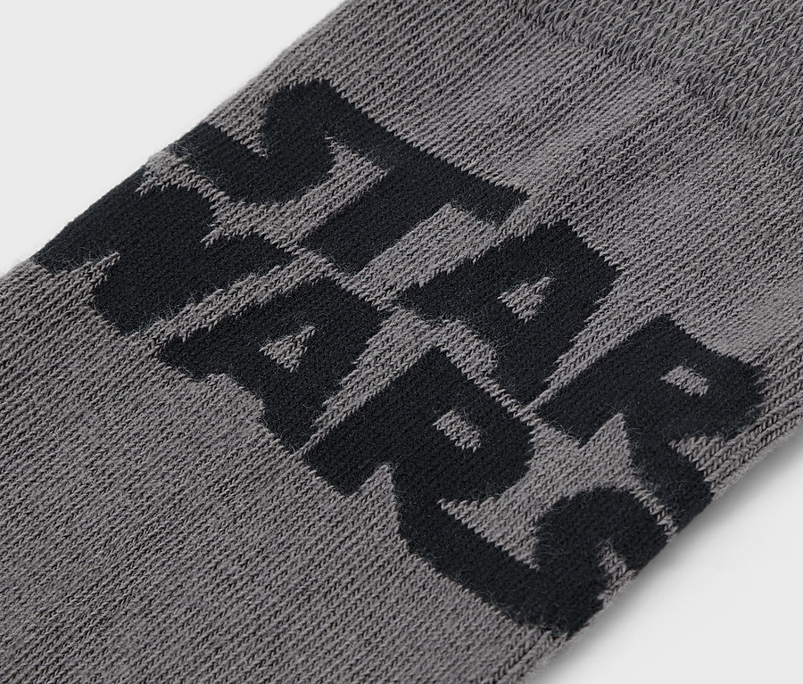 Detailaufnahme einer grauen Socke mit schwarzem STAR WARS Schriftzug.