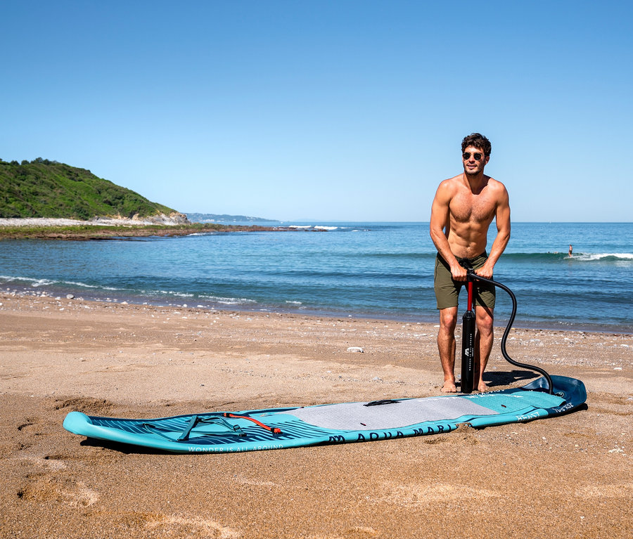 Mann pumpt Aqua Marina SUP Boad »Beast« 10'6" am Strand auf.