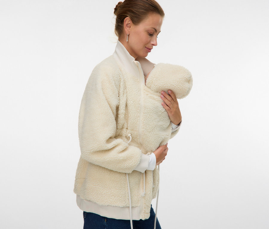 Frau hält Baby in der MAMALICIOUS MLCARLY 3IN1 TEDDY JACKE. Die Jacke ist hellbeige und aus Teddyfell.