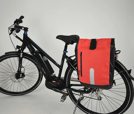 Schwarzes Fahrrad mit FISCHER wasserdichter Gepäckträgertasche in Rot und Schwarz am Gepäckträger.