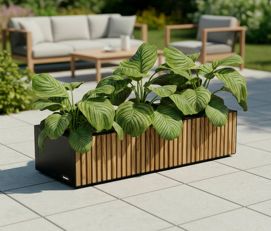 Draufsicht auf einen rechteckigen Pflanzkasten mit vertikalen Holzpaneelen und grünen Pflanzen, im Hintergrund Gartenmöbel.