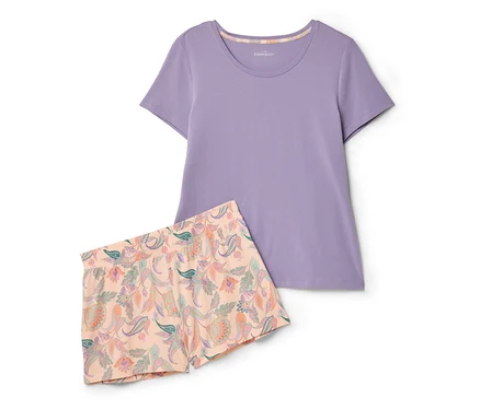 Ein lilafarbenes T-Shirt und Shorts mit Blumenmuster liegen zusammen.