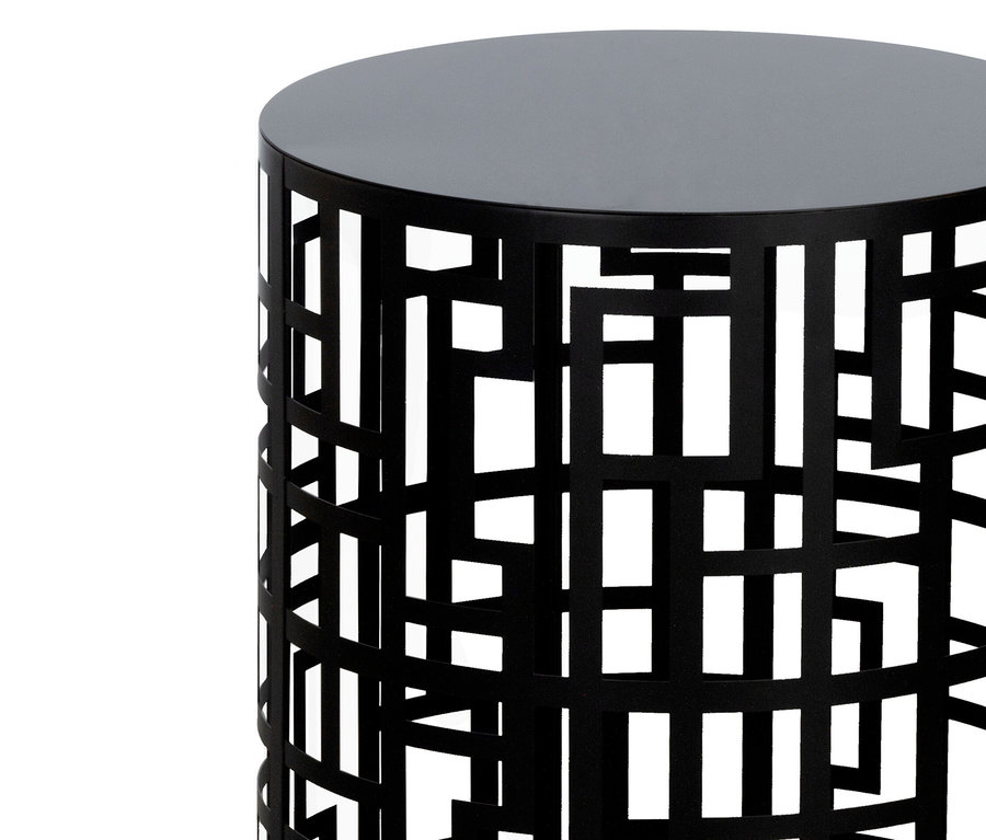Nahaufnahme eines schwarzen Beistelltisches mit geometrischem Ausschnittmuster vor einem weißen Hintergrund.