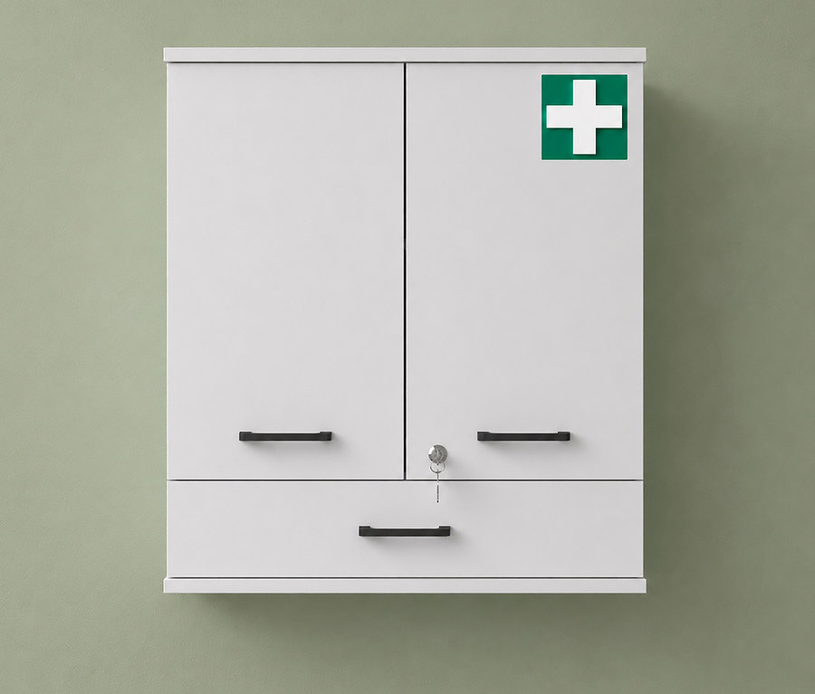 Matter weißer Medizinschrank »Galeno« mit zwei Türen, einer Schublade, schwarzen Griffen, Schloss mit Schlüssel und einem grünen Erste-Hilfe-Kreuz, an einer grünen Wand.