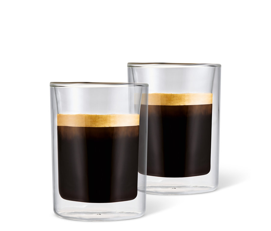 Zwei mit Kaffee gefüllte Caffè Crema Gläser mit Schaum vor einem weißen Hintergrund.