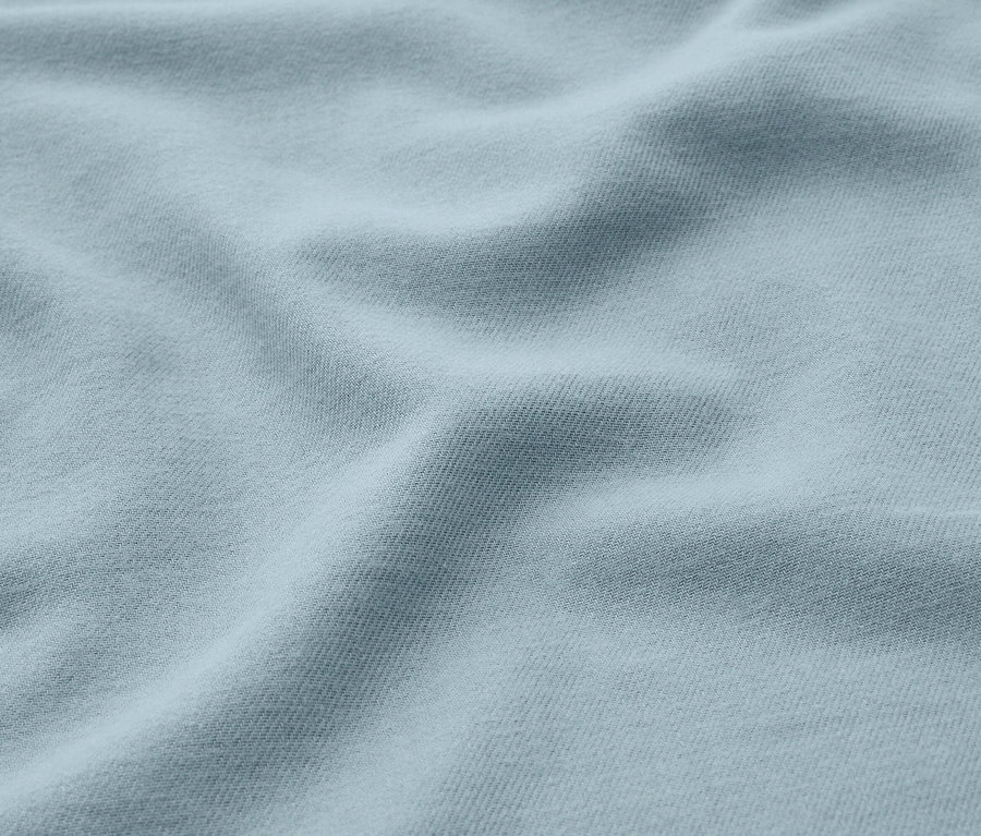 Helles blaues Stoffgewebe mit weichen Falten und Schatten.