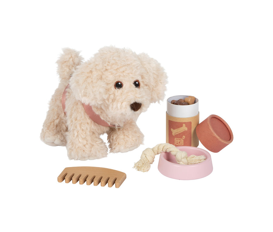 Ein cremefarbener small foot Plüschhund mit rosa Gurtzeug, Holzkamm, braunem Leckerli-Behälter und rosa Napf mit Seilspielzeug.